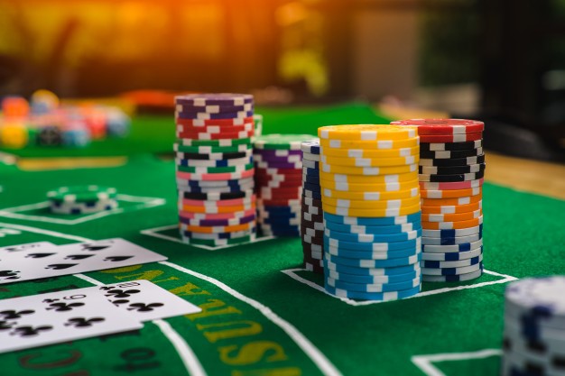 spelmarker i olika färger på blackjackbord